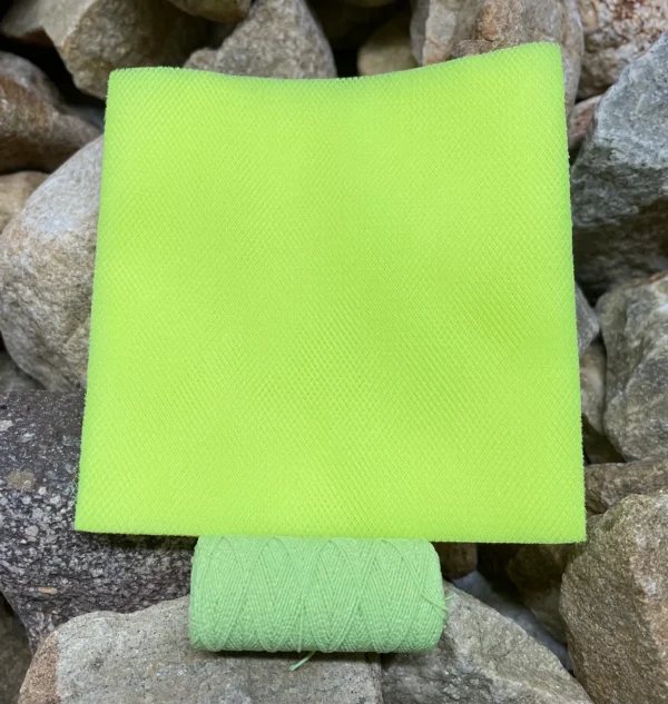 A green square shaped object sitting on top of rocks.