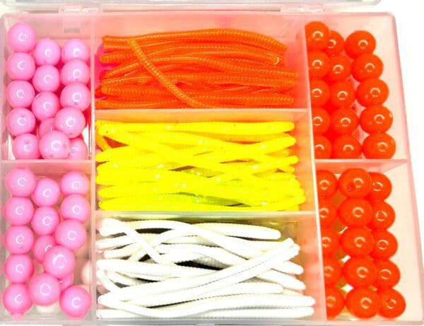 A plastic container filled with different types of beads.