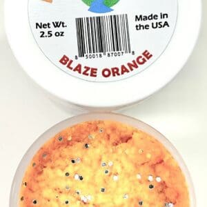 A container of orange ice cream with black and white sprinkles.