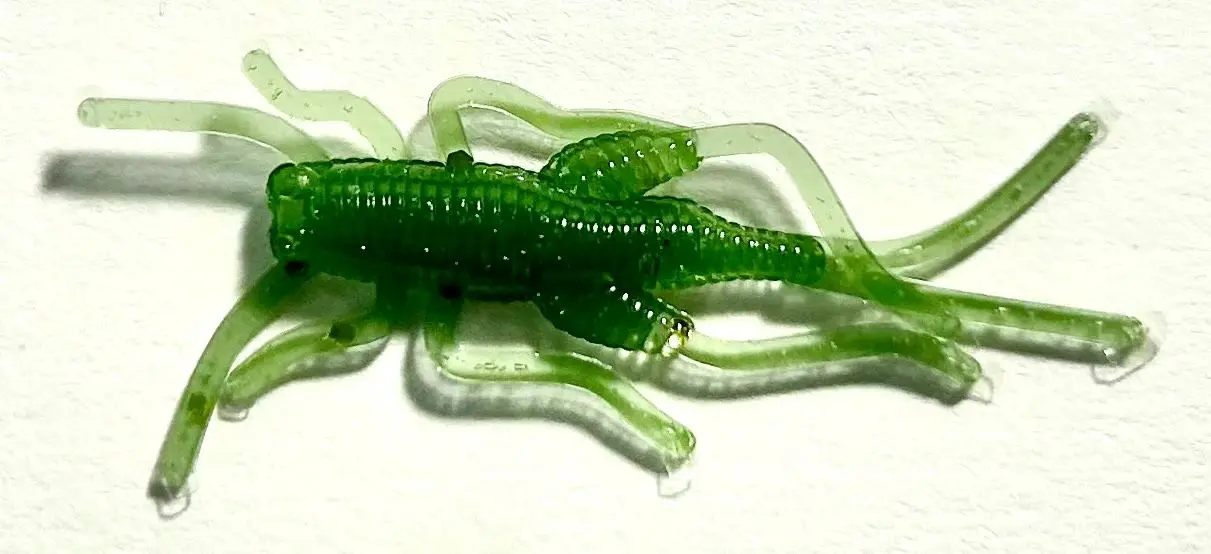 A green plastic animal is laying on its back.