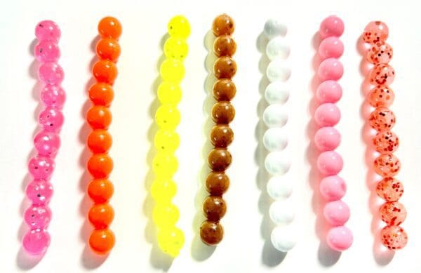 A group of different colored beads sitting on top of each other.