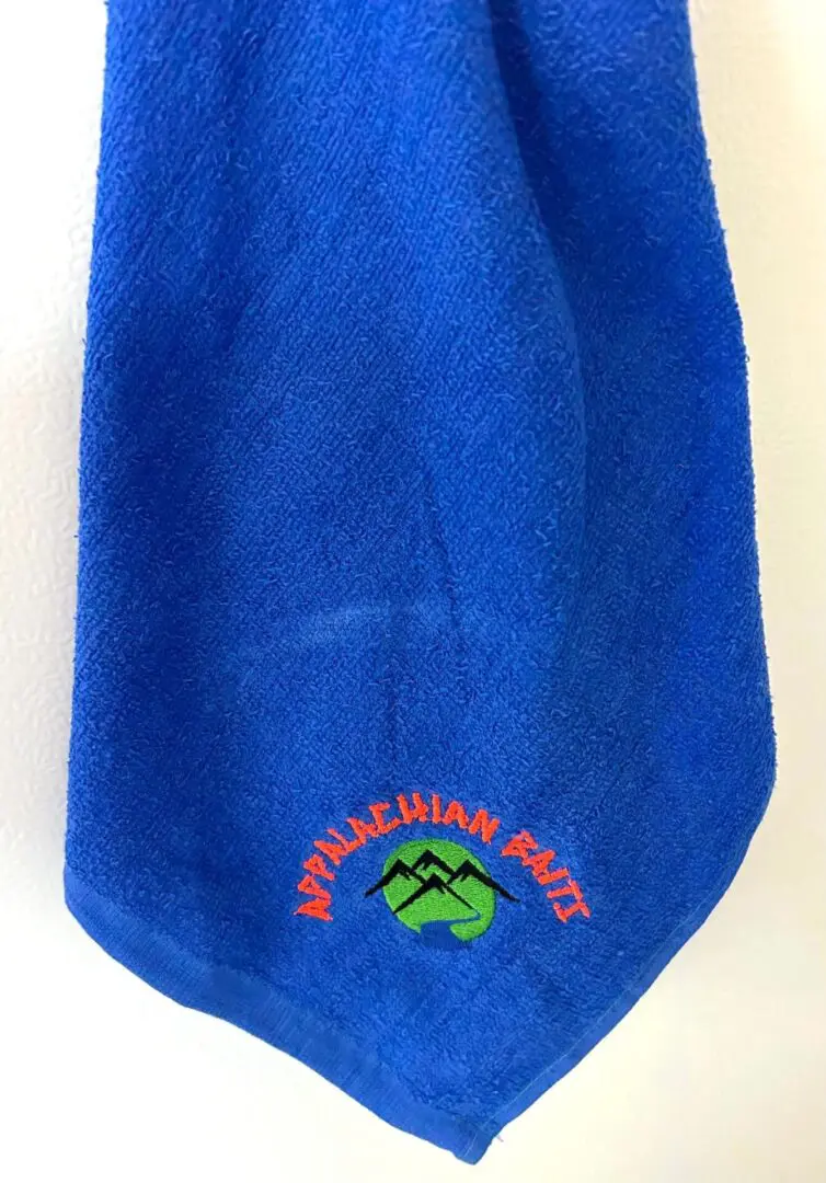 A blue towel with an embroidered logo.