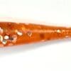 A close up of an orange stick with white and red sprinkles