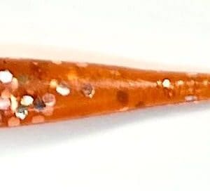 A close up of an orange stick with white and red sprinkles