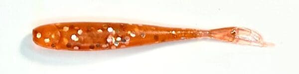 A close up of an orange stick with white and red sprinkles