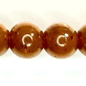 A string of brown beads with white writing on it.