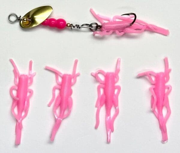 A pink fishing lure with several different types of plastic.