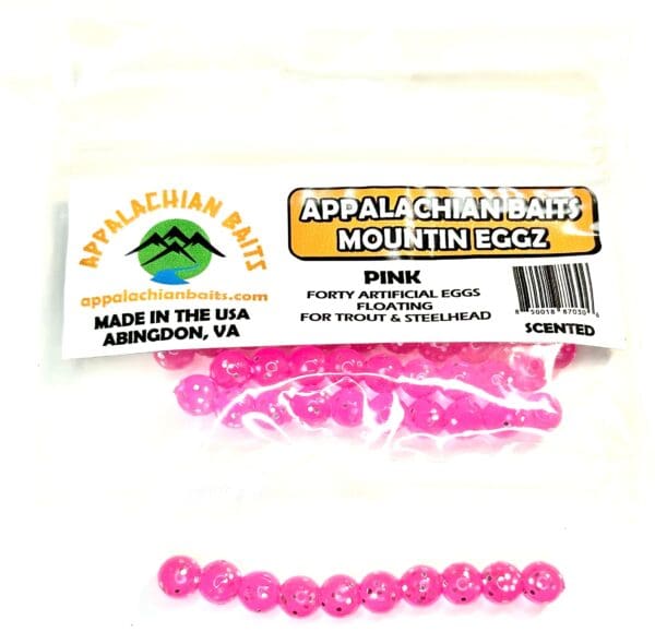 A package of pink beads and a stick of wax.