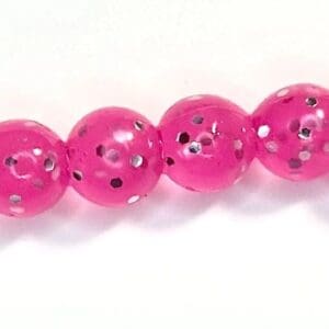 A pink bead with black and white polka dots.