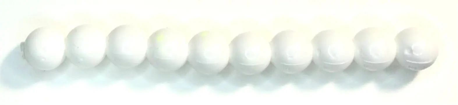 A row of white balls sitting on top of each other.