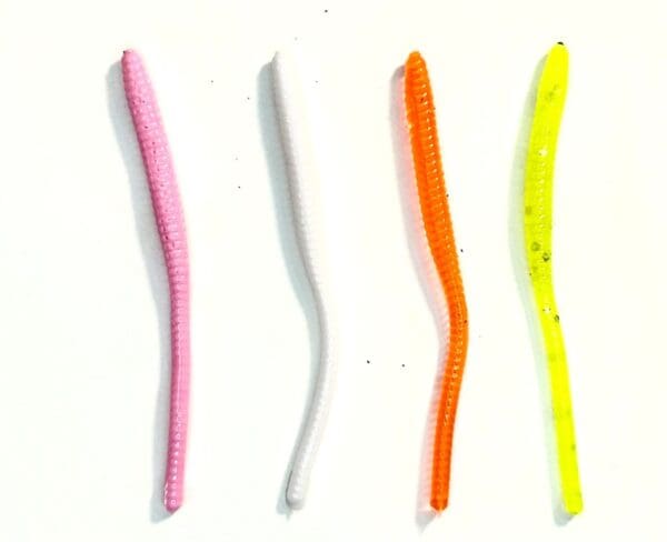 A group of four different colored plastic worms.