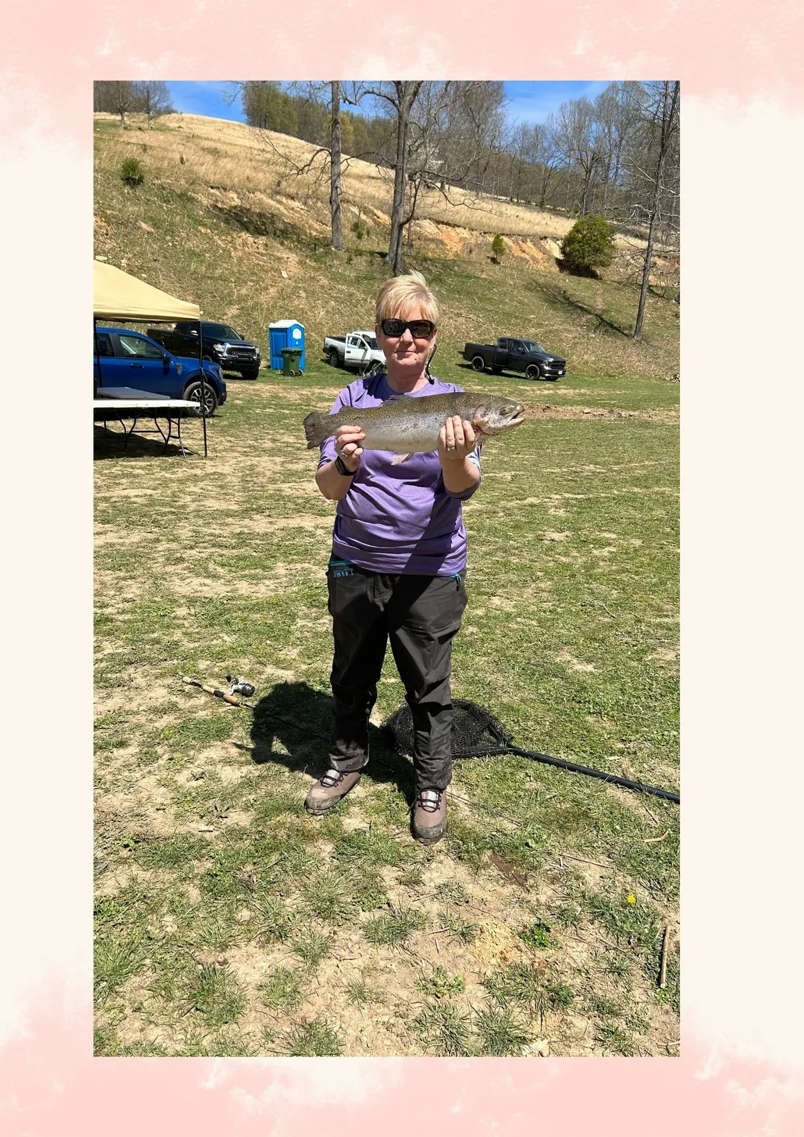 A woman holding up a fish in her hands.